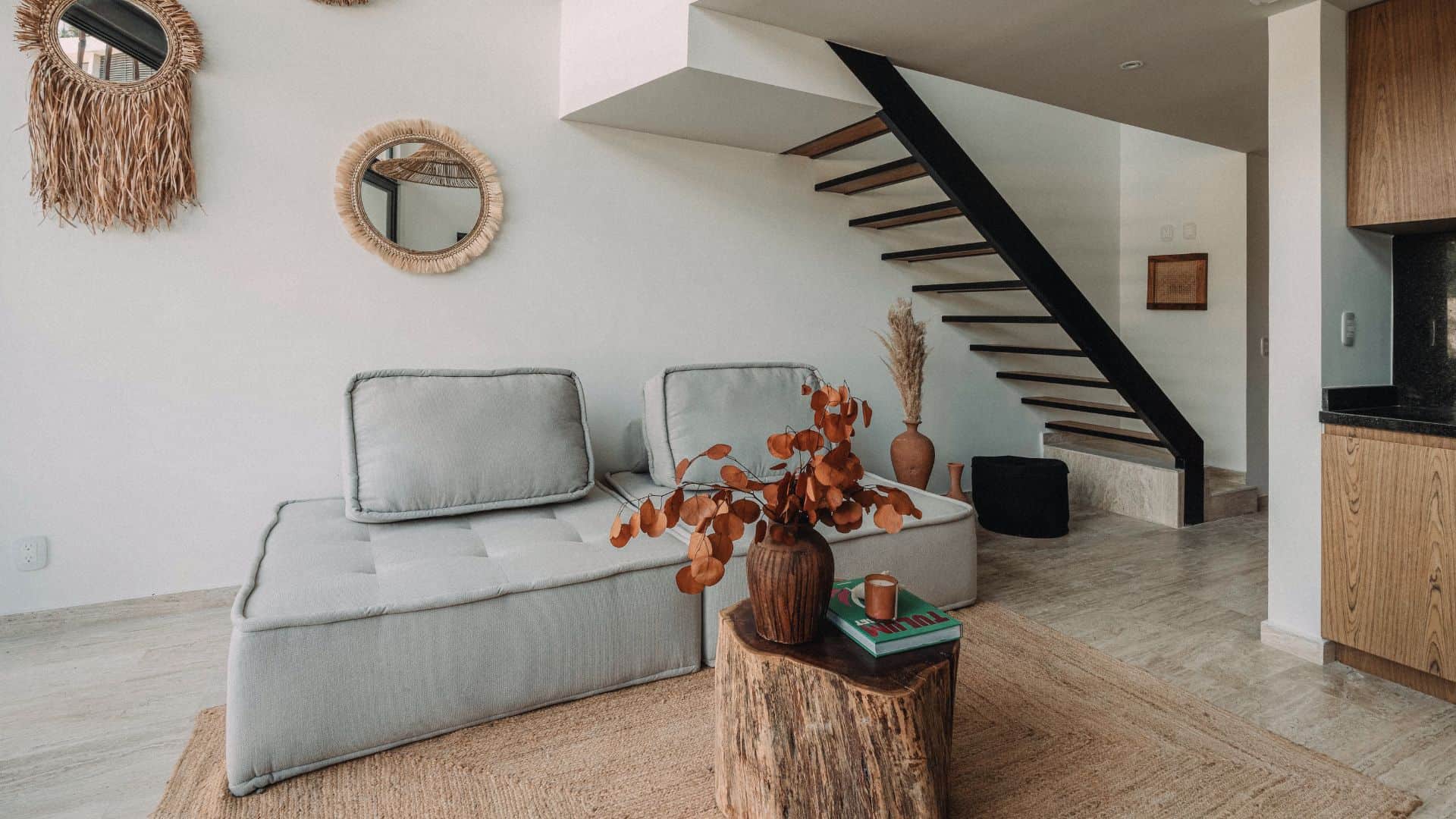 Open-concept living room in LENEVA LOFT with modern decor and large windows. Accommodation in Tulum.